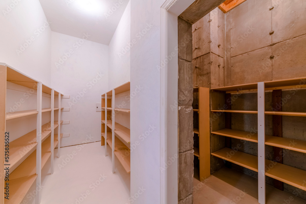 Interior view of a walk in closet or pantry with empty wooden shelves ...