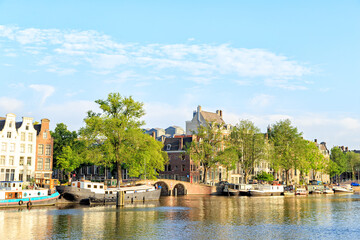 Amsterdam, Netherlands - June 30, 2019: Residential barges and houses on the water. Amstel River.The historic city center.