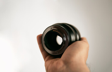 Man hand holds a portrait lens. Isolated photo of a modern lens in hand