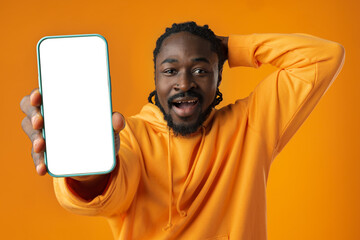 Smiling african man pointing at cellphone with blank screen with copy space