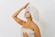 © Westend61 - Woman wearing facial sheet mask standing in front of white wall