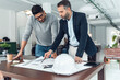 © Westend61 - Businessman explaining and having discussion with colleague over blueprint at office