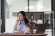 © Songsak C - Sad Asian woman looking annoyed and stressed, sitting at the desk, using a laptop, thinking, feeling tired and bored with depression problems