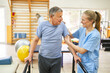 © Robert Kneschke - Physiotherapist assisting senior man in movement therapy