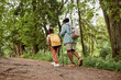 © Seventyfour - Back view of black mother and daughter hiking together in nature and walking uphill, copy space