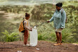 © Seventyfour - Side view portrait of eco activist mother and daughter helping clean nature and picking plastic bottles outdoors