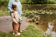 © Seventyfour - Portrait of black little girl holding fishing rod and enjoying time in nature with mother, copy space