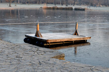 Wooden Raft Is Tied To A Taut Rope. Self-service Ferry Across River, Pond. People Get And Pull Their Hands Other Bank By Own Strength. Floating Pier On Lake.winter, Frost, Ice, Grab Rope, Prepare
