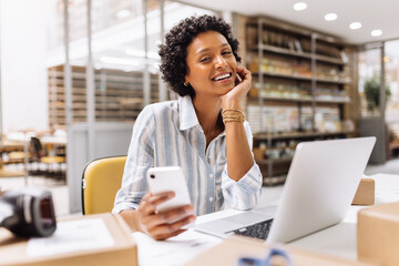 Successful online store owner smiling at the camera in a warehouse