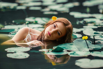 Wall Mural - Beautiful red haired girl in white dress posing in river with water lilies. Fairytale story about  ophelia .Warm art work.