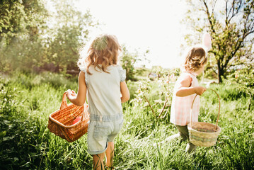 Easter egg hunt. Group Of Children Wearing Bunny Ears Running To Pick Up colorful Egg On Easter Egg Hunt In Garden. Easter tradition