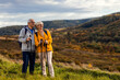 © Zoran Zeremski - Active senior couple with backpacks hiking together in nature on autumn day.