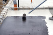 Worker applying a bituminous primer on a Concrete Slab Before Waterproofing