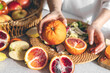 © puhimec - Oranges in female hands on the kitchen table, close-up.