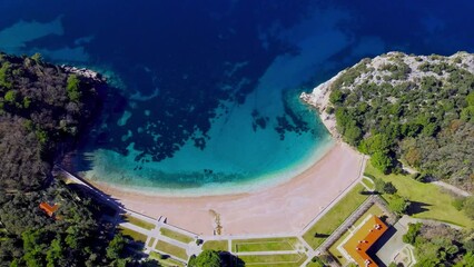Wall Mural - Stunning scenery from the beach to the sea. Sandy shore, blue water and waves crashing on the shore. Paradise place. Sunny day. Top view from a drone.