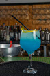 © Rafa - hombre barman con gorro de vaquero preparando un cóctel azul en la barra del bar