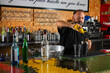 © Rafa - hombre barman con gorro de vaquero preparando un cóctel azul en la barra del bar