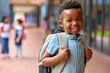 Portrait Of Smiling Male Elementary School Pupil Outdoors With Backpack At School