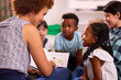 © Monkey Business - Female Teacher Reads To Multi-Cultural Elementary School Pupils Sitting On Floor In Class  At School