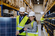 © Halfpoint - Warehouse workers checking stuff in warehouse with digital system in tablet, holding solar panel.