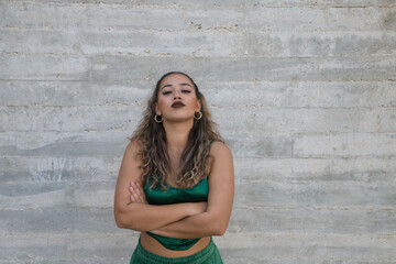 Wall Mural - Portrait of Latin woman, young and beautiful dancing modern dance on a gray cement background on the street making different expressions and postures. Concept dance, art, action, beauty, youth art.