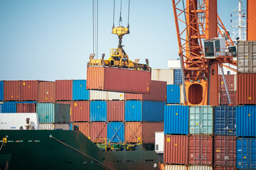 Wall Mural - Harbor crane unloads containers from cargo ship at pier. Logistics, international trade transportation. Import and export of goods.