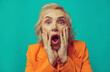 © VISTA by Westend61 - Shocked senior woman against turquoise background