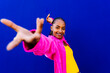 © VISTA by Westend61 - Smiling young woman dancing in front of blue wall