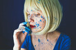 © VISTA by Westend61 - Woman with blue powder paint on face against blue background
