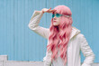 © VISTA by Westend61 - Young woman with pink hair searching in front of blue wall