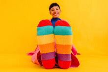 Woman Wearing Colorful Socks Over Yellow Background