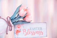 TENDER PINK FLOWERS TULIPS In A Vase And A Wooden Vintage Daughter With The Inscription "Happy Easter".  Free Place. Gradient Gentle Pink Background.
