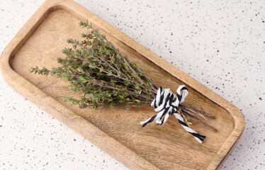 Wall Mural - Sprigs of thyme tied with rope  on a wooden plate, top vew