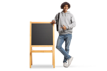 Sticker - Full length portrait of an african american male student leaning on a blackboard and pointing