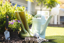 Close Up Of Watering Can, Shovel And Rain Boots In Garden