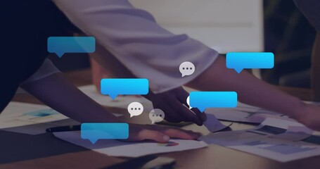 Poster - Animation of message icons against mid section of colleagues discussing over documents at office