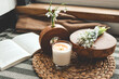 Burning candle and beautiful flowers on wooden table indoors