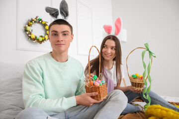 Wall Mural - Happy young couple with baskets of Easter eggs in bedroom