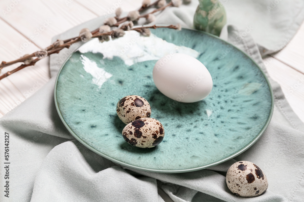 Table setting with Easter eggs and pussy willow branches on white wooden background
