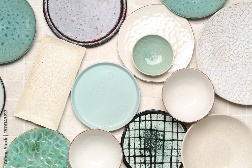 Composition with clean ceramic plates and bowls on tile background