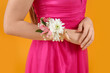 Young girl in prom dress and with corsage on yellow background, closeup