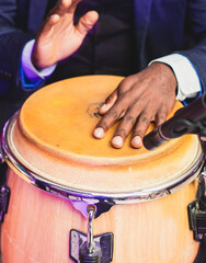 Wall Mural - Bongo drummer percussionist performing on a stage with conga drums set kit during jazz rock show performance, tumbadora quinto with latin cuban afro-cuban jazz band performing in the background