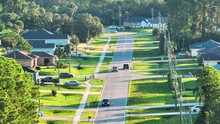 Aerial View Of Street Traffic With Driving Cars In Small Town. American Suburban Landscape With Private Homes Between Green Palm Trees In Florida Quiet Residential Area