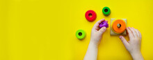 Children's Wooden Figures On A Yellow Background. The Child Collects The Pyramid..Sensory Educational Games. Development Of Fine Motor Skills In Kindergarten. Baby's Classes