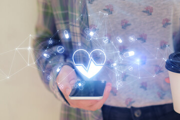 Poster - Close up of hand using phone with glowing heart hologram on blurry background. Cardiology and doctor's office concept. Double exposure.
