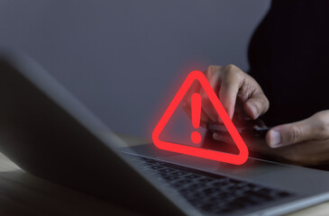 Wall Mural - businessman using laptop showing warning triangle and exclamation sign icon caution of dangerous pro