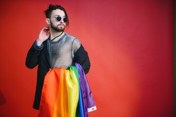 Young, handsome gay man on a colored background in the studio. LGBT concept.