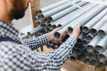 New steel pipes. A worker at the factory.