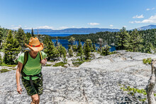 A Female Hiker Moving Cross Country High Above Cascade Lake And Lake Tahoe.