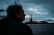 © Cavan Images - Profile of girl looking at statue of liberty at dusk